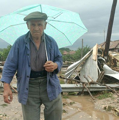 Възрастен човек минава покрай останки от разрушена къща от приливната вълна в Цар Калоян