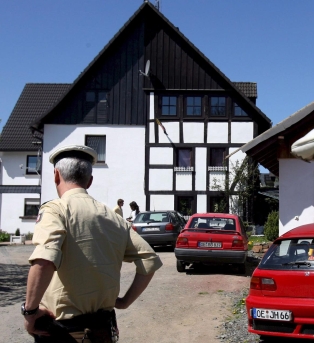 Германски полицай пред къщата, в която са намерени замразените бебета