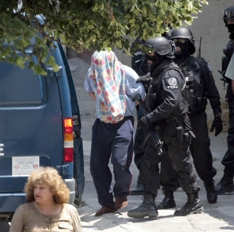 Полицаите водят единия от задържаните в кв. Аспарухово