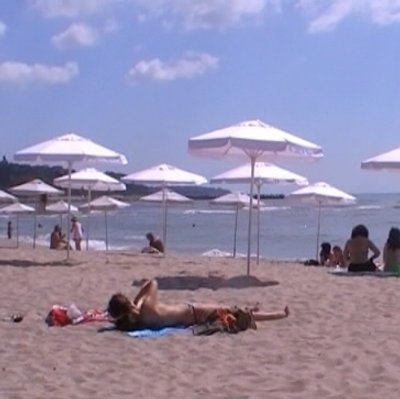 Край на плажа, покрит с платени чадъри