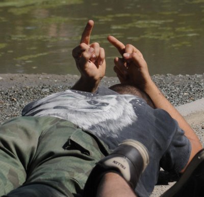 Един от задържаните противници на гейпарада показва среден пръст на полицаите