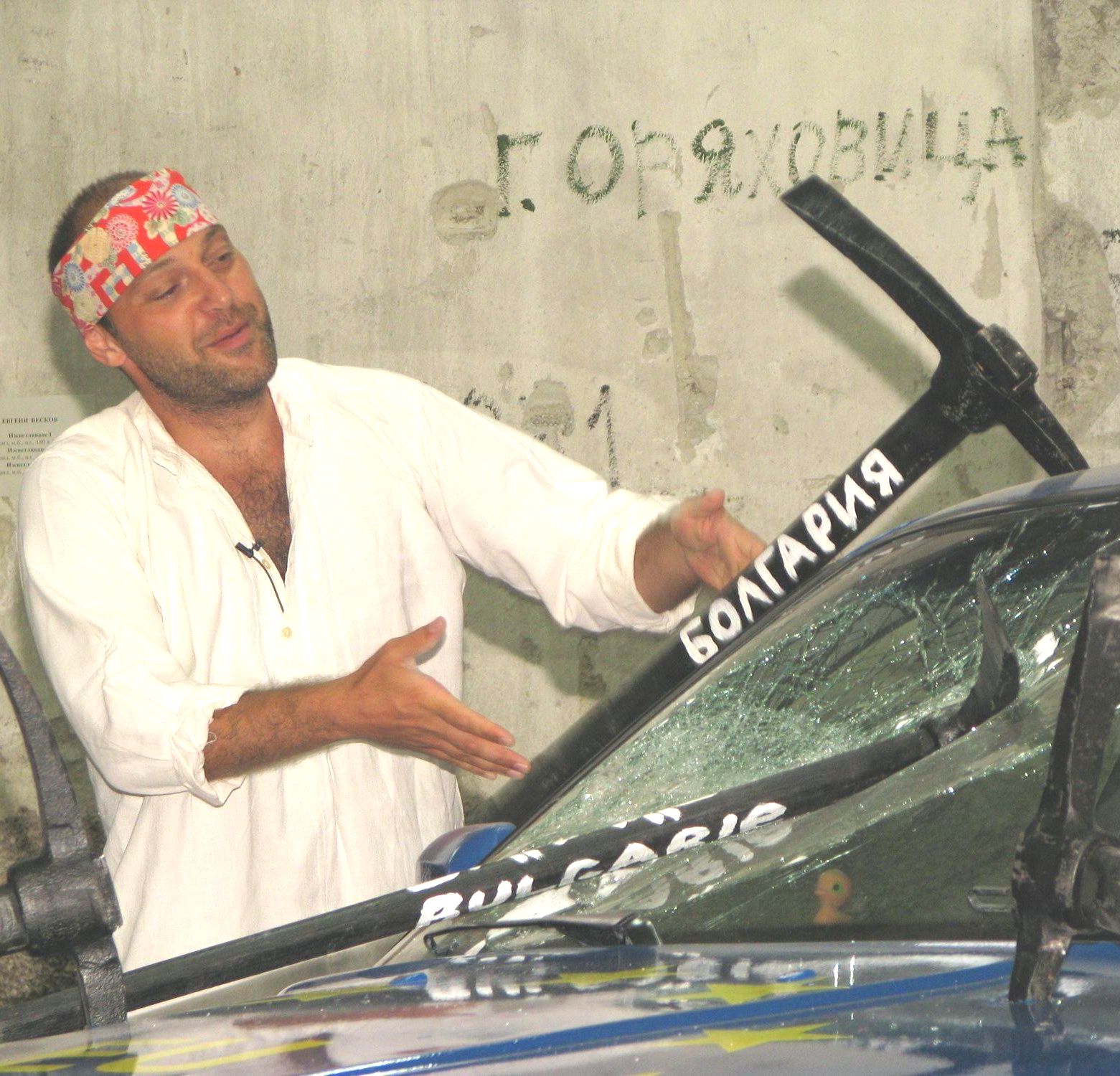 Художник забива кирки в кола на изложба