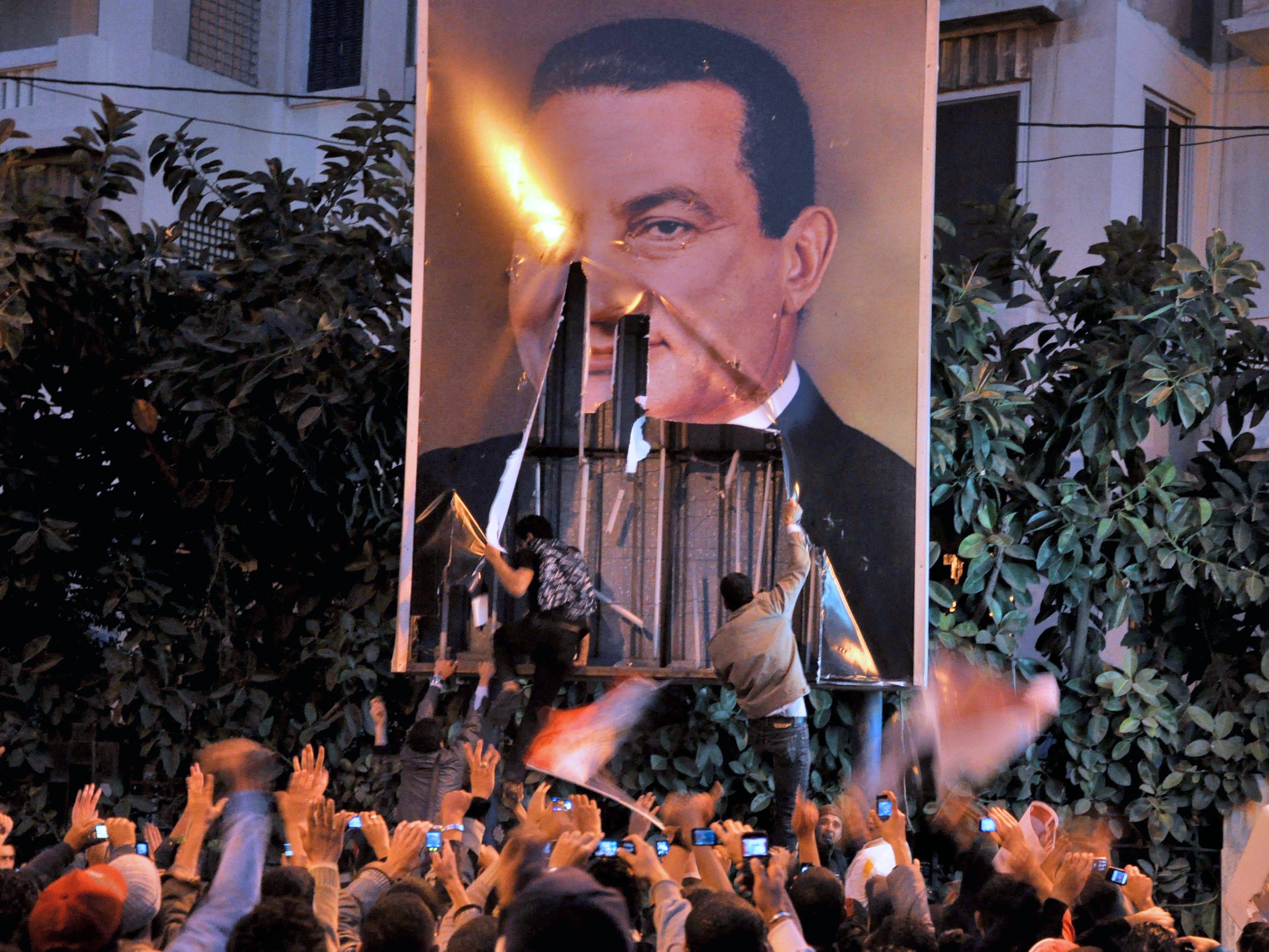 Египетски протестиращи събарят плакат на Хосни Мубарак при протестите преди да падне режимът