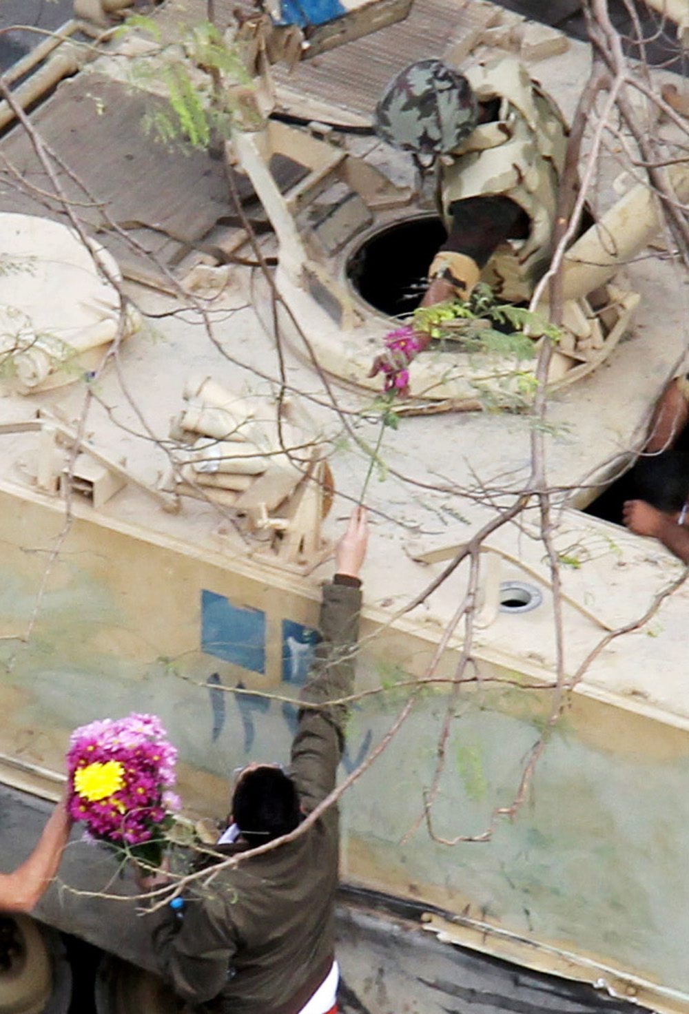 Доменстрант подава цветя на войник в танк