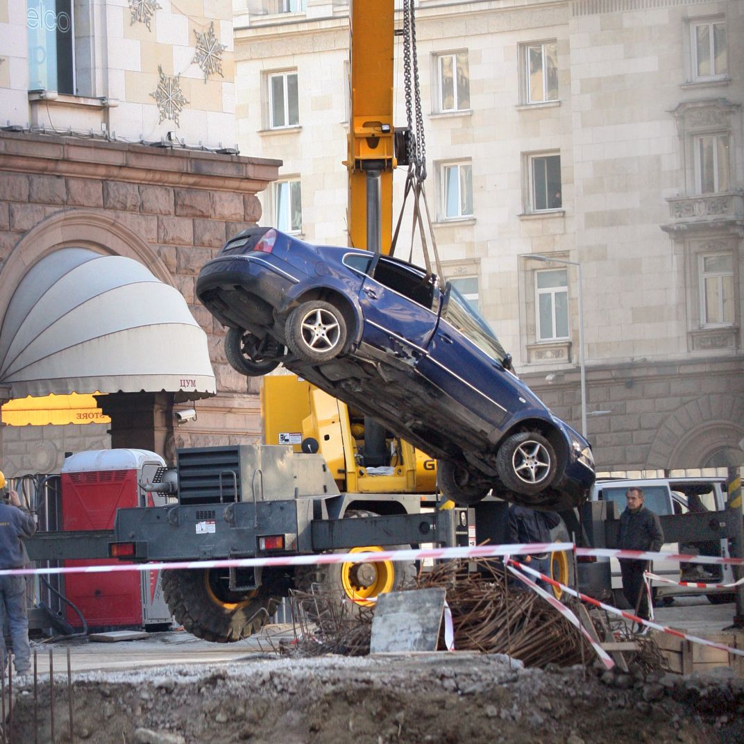 Кола падна в изкопа за метрото пред ЦУМ (Снимки)