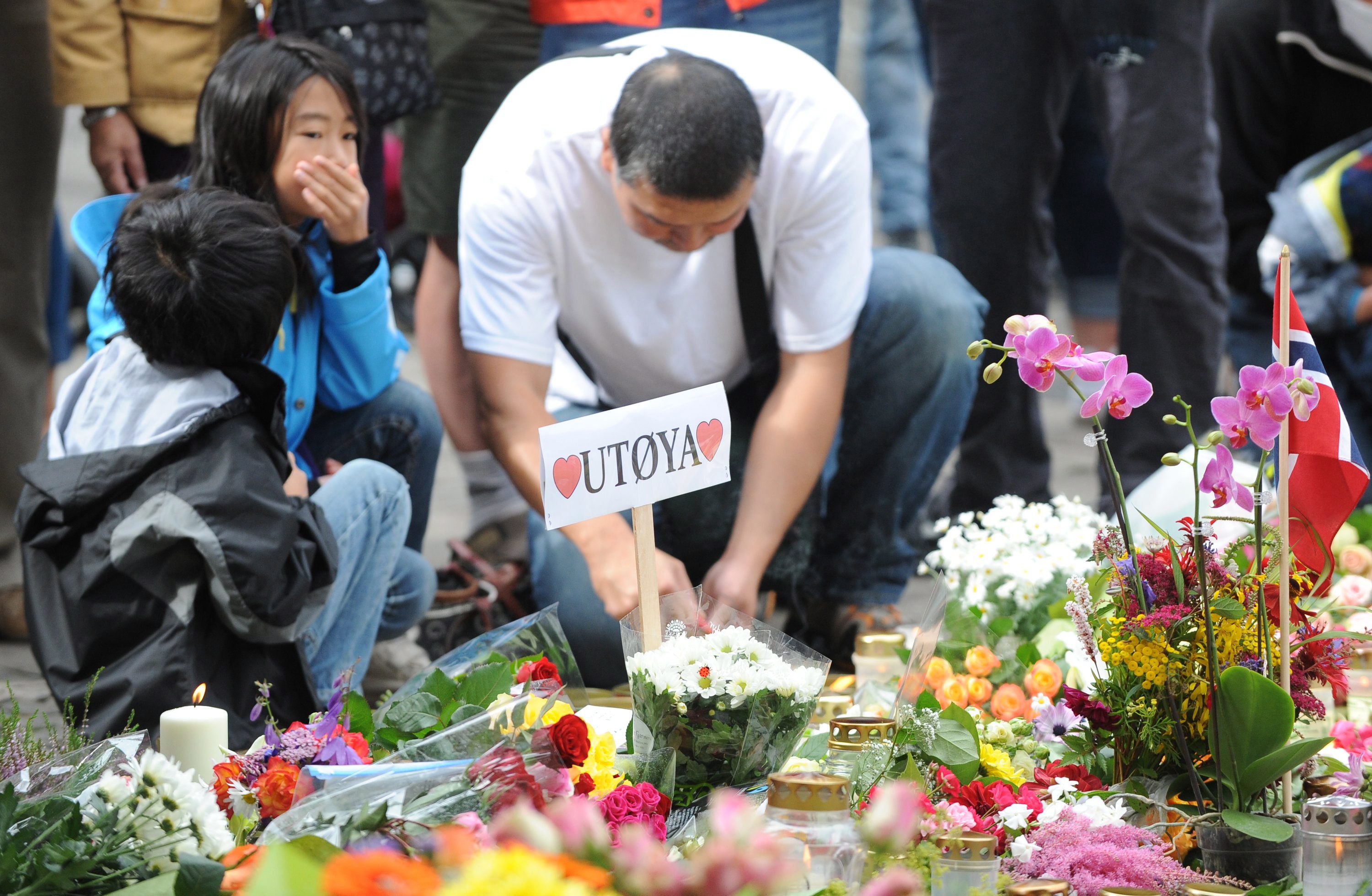 Мъж в Осло поставя цветя в памет на загиналите