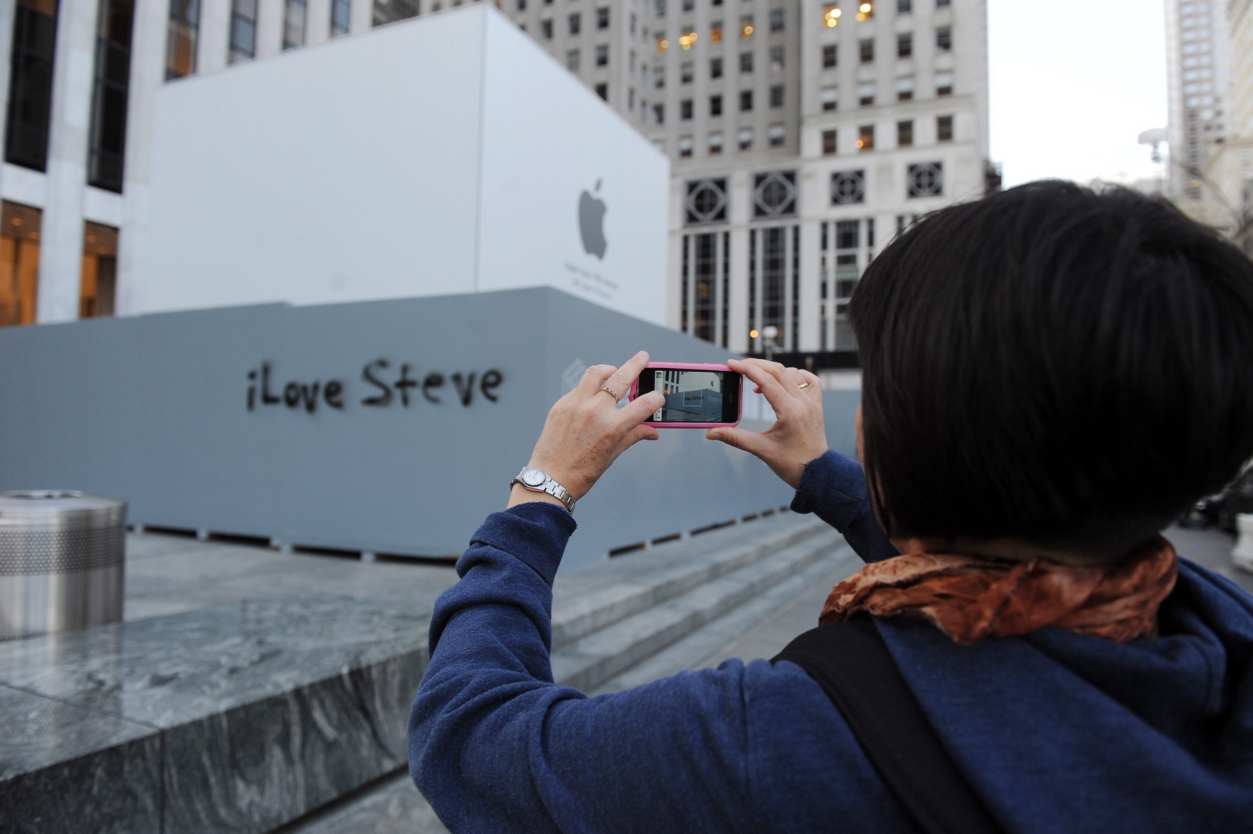 Жена заснема надпис ”iLove Steve” (Обичам Стив) на стената на магазина на Apple в Ню Йюрк