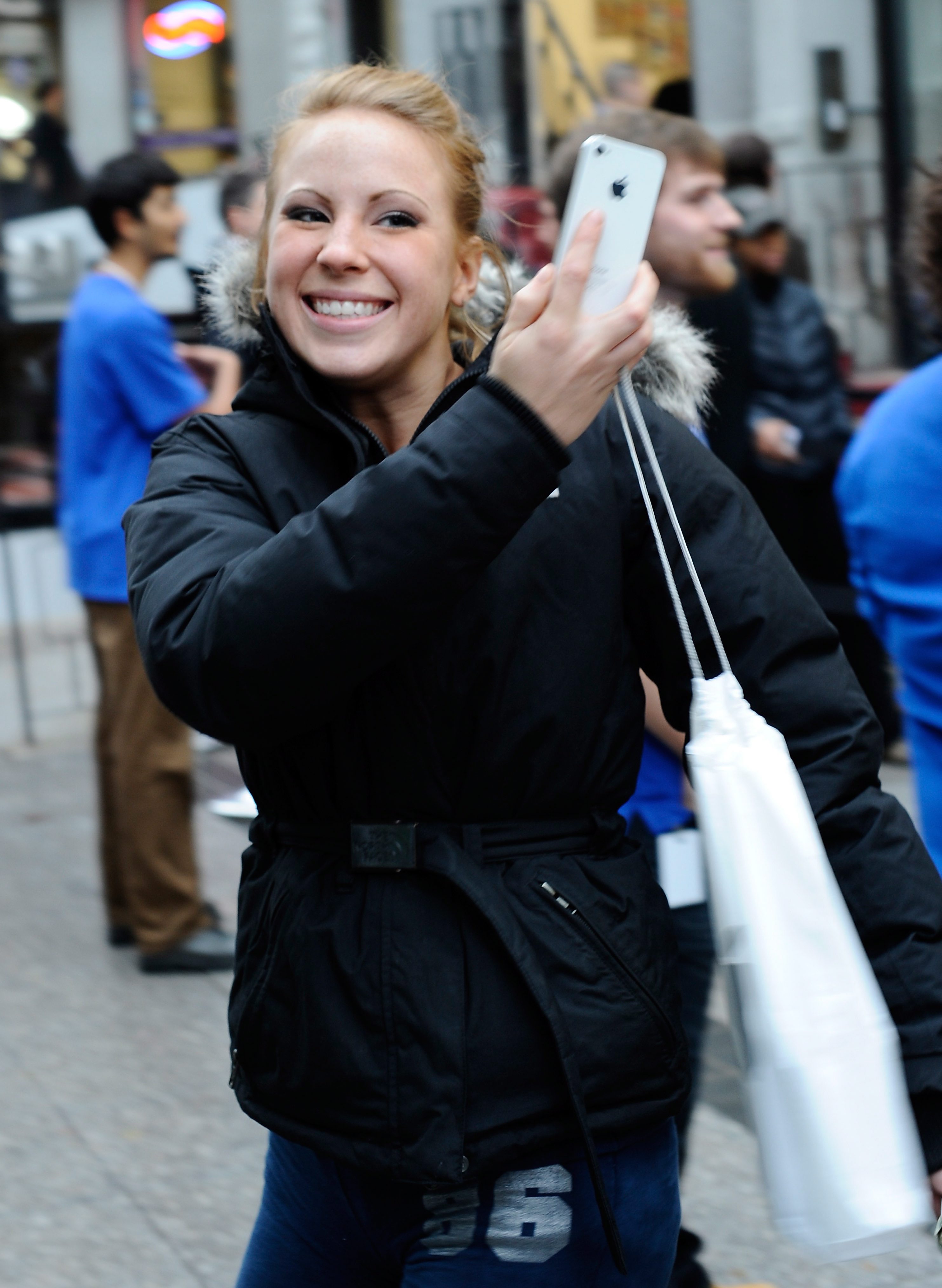 Щастлива клиентка показва новия си iPhone 4S в САЩ