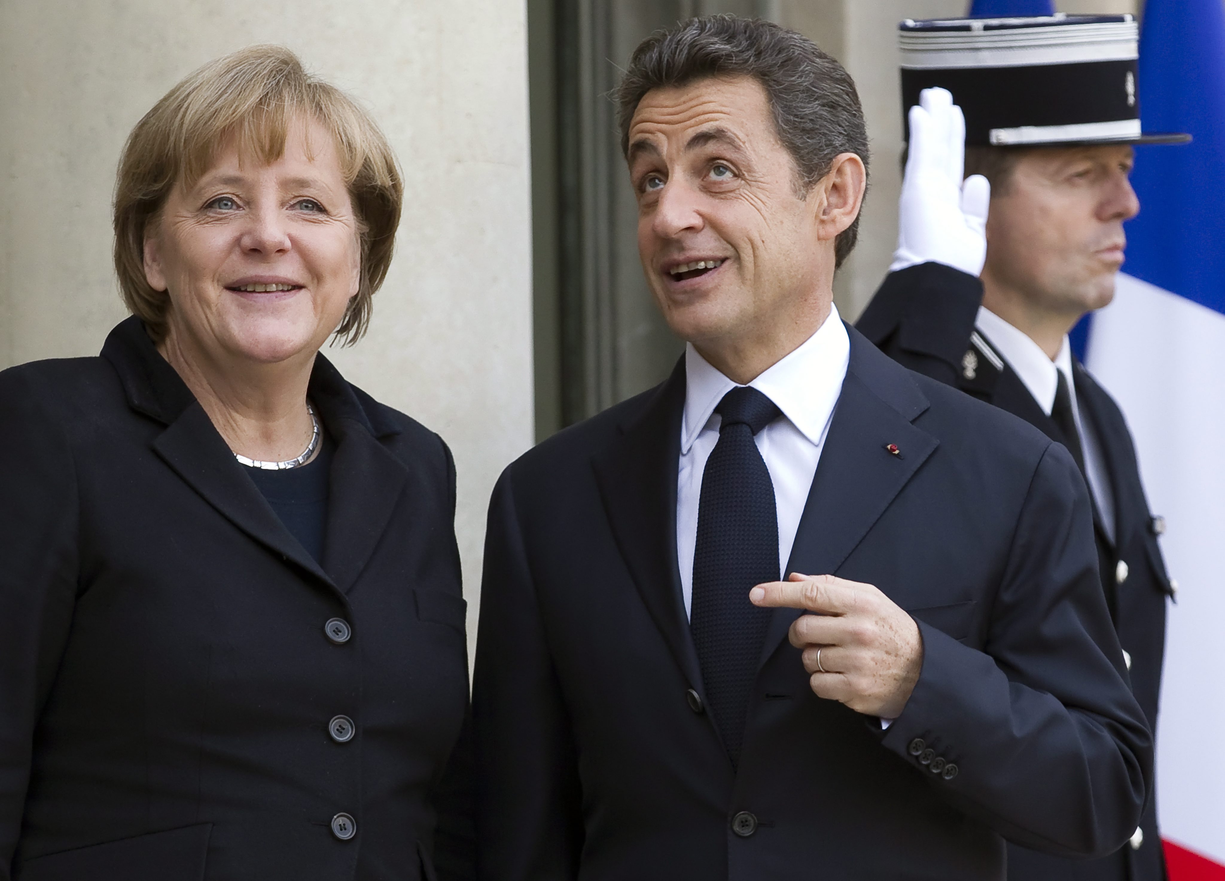 Френският президент посрещна Меркел на стълбищната площадка пред входа на президентския дворец.