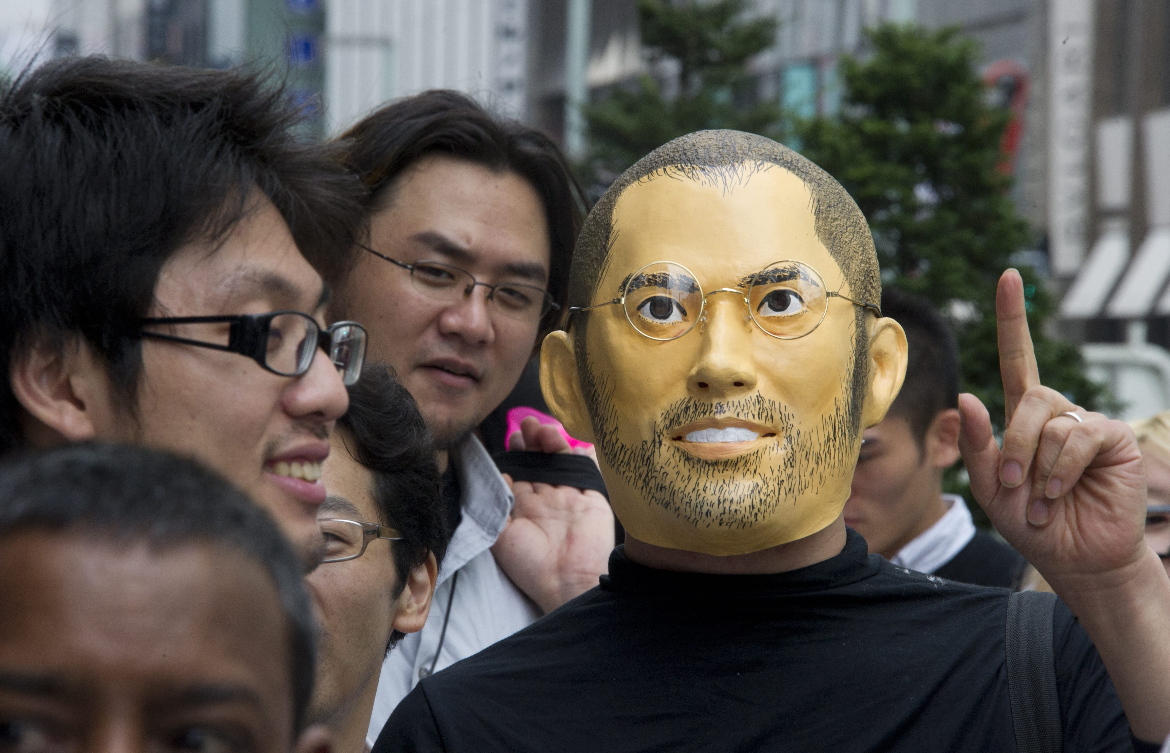 Фен на Apple с маска на Стив Джобс на опашка за iPhone 5 в Япония