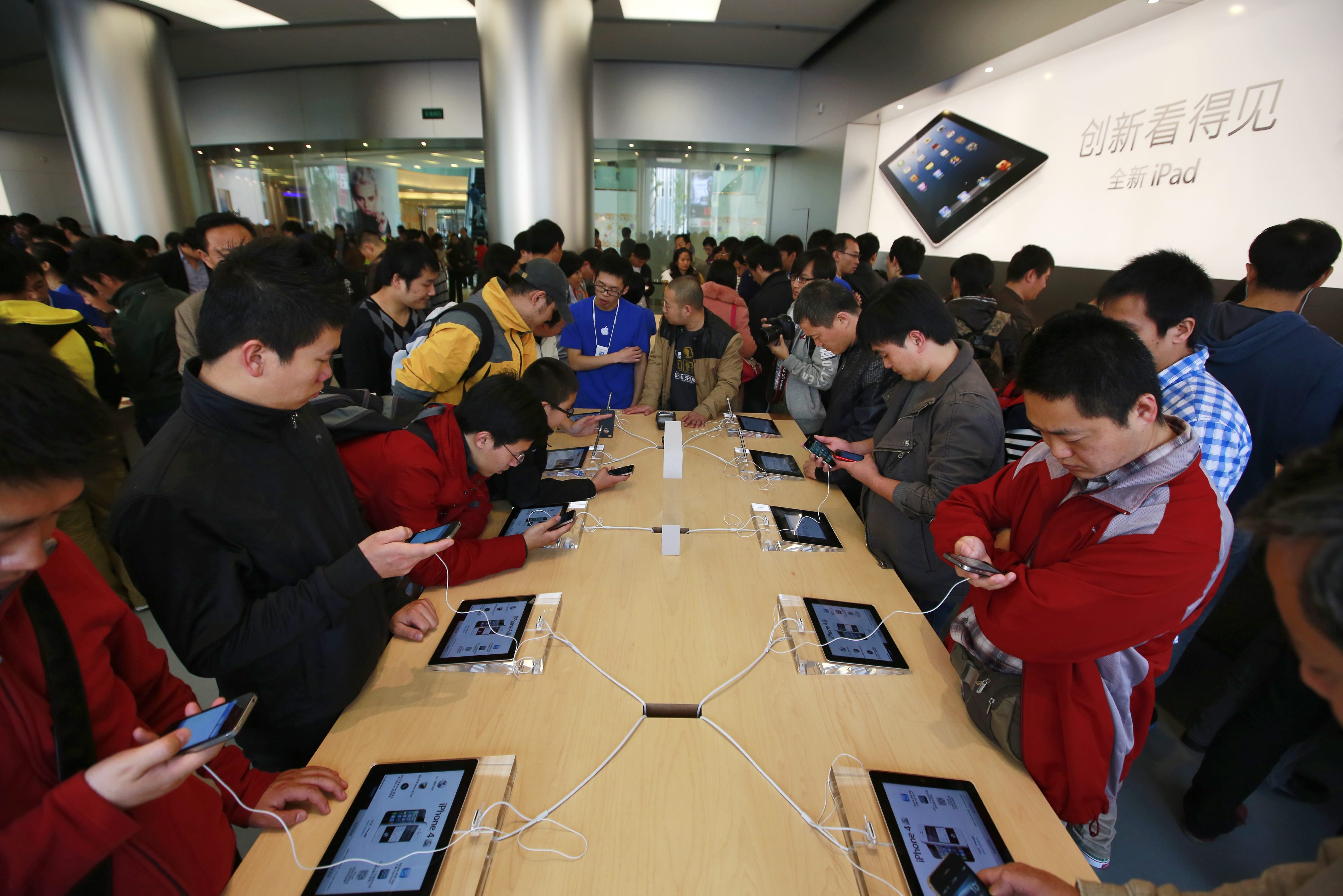 Първите клиенти на новия магазин разглеждат продуктите на Apple