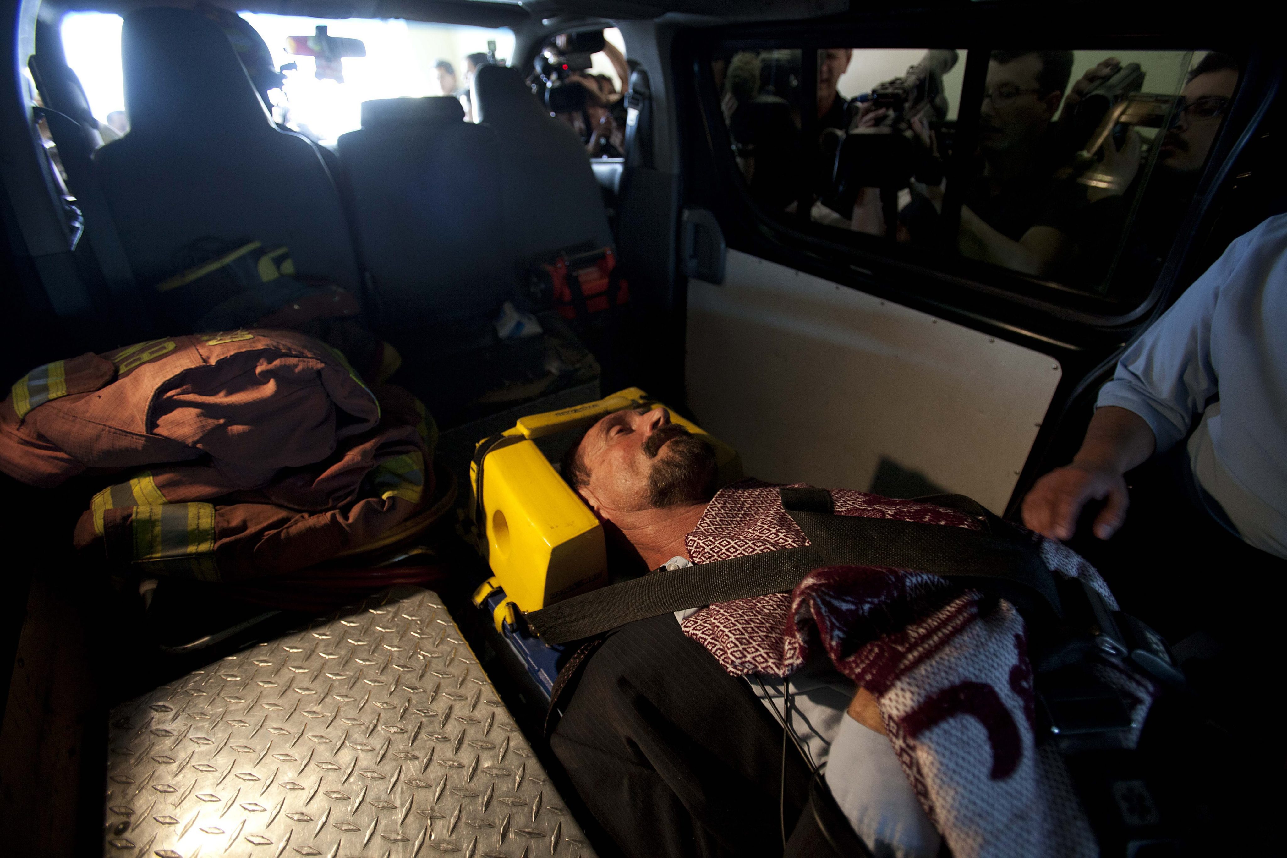Джон Макафи в линейка на път за болница в Гватемала