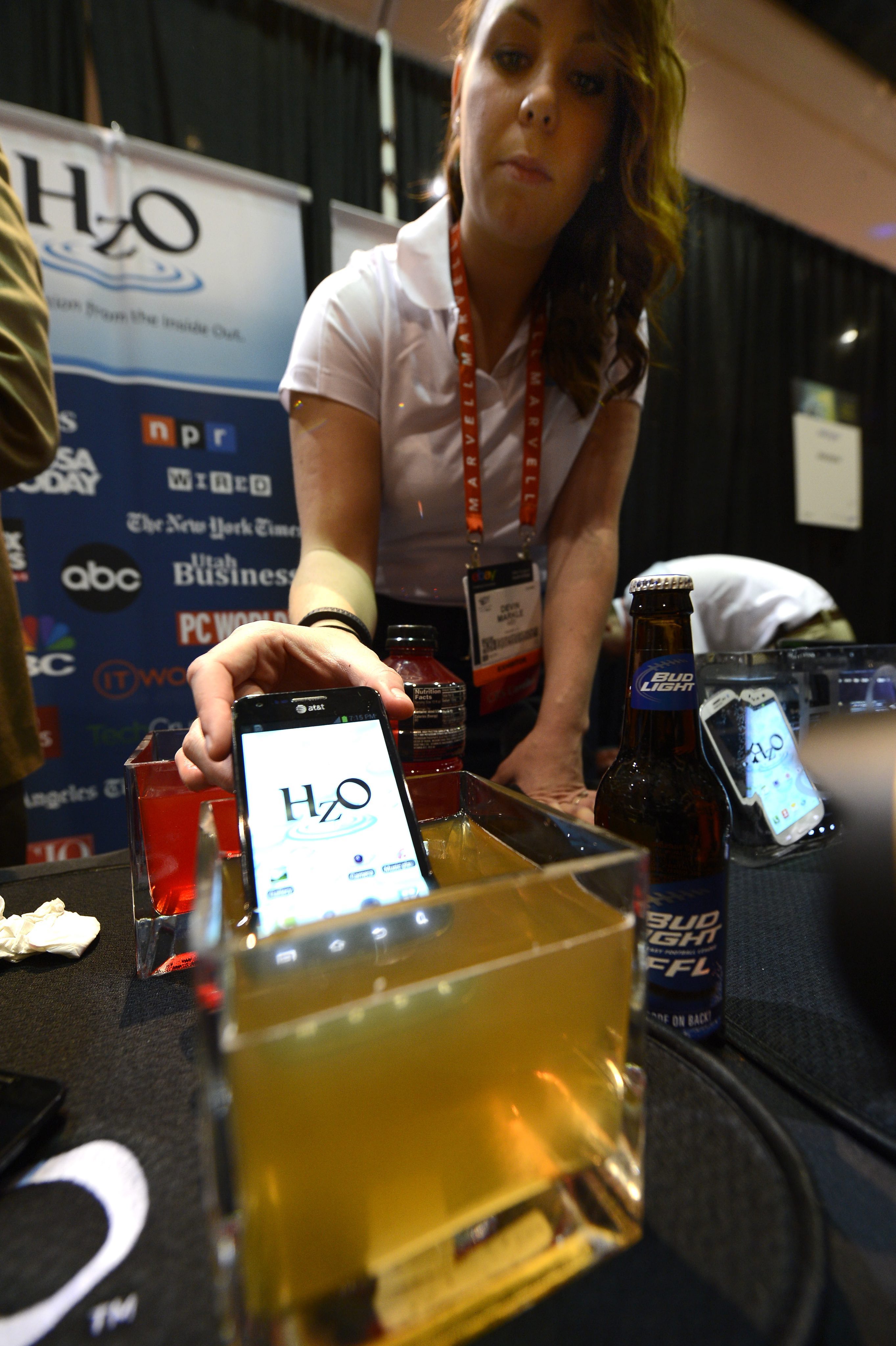 CES 2013 - Служителка от HzO показва технология за предпазване от влага на ел. устройства