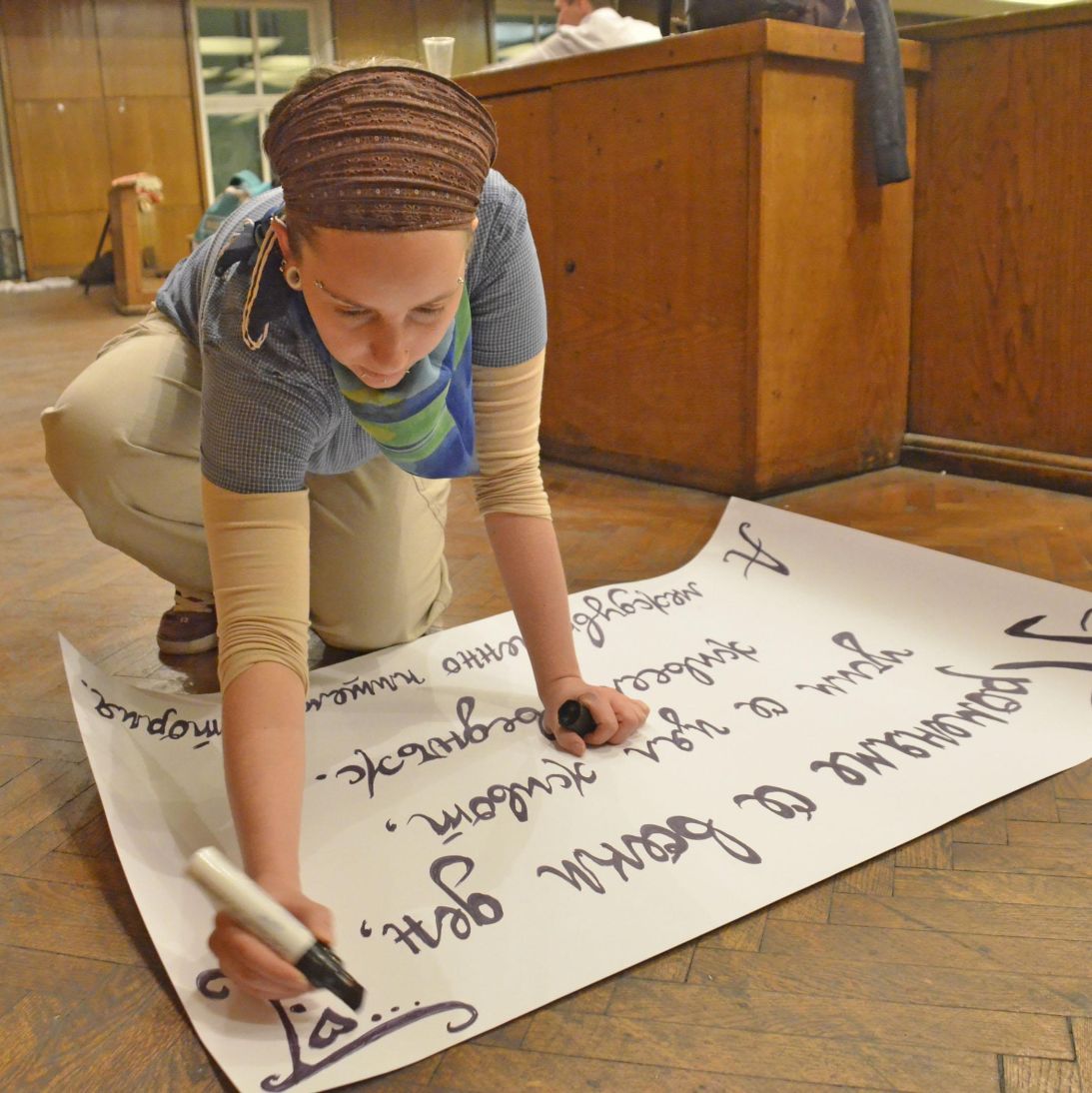 Студентка надписва плакат за Окупацията в СУ
