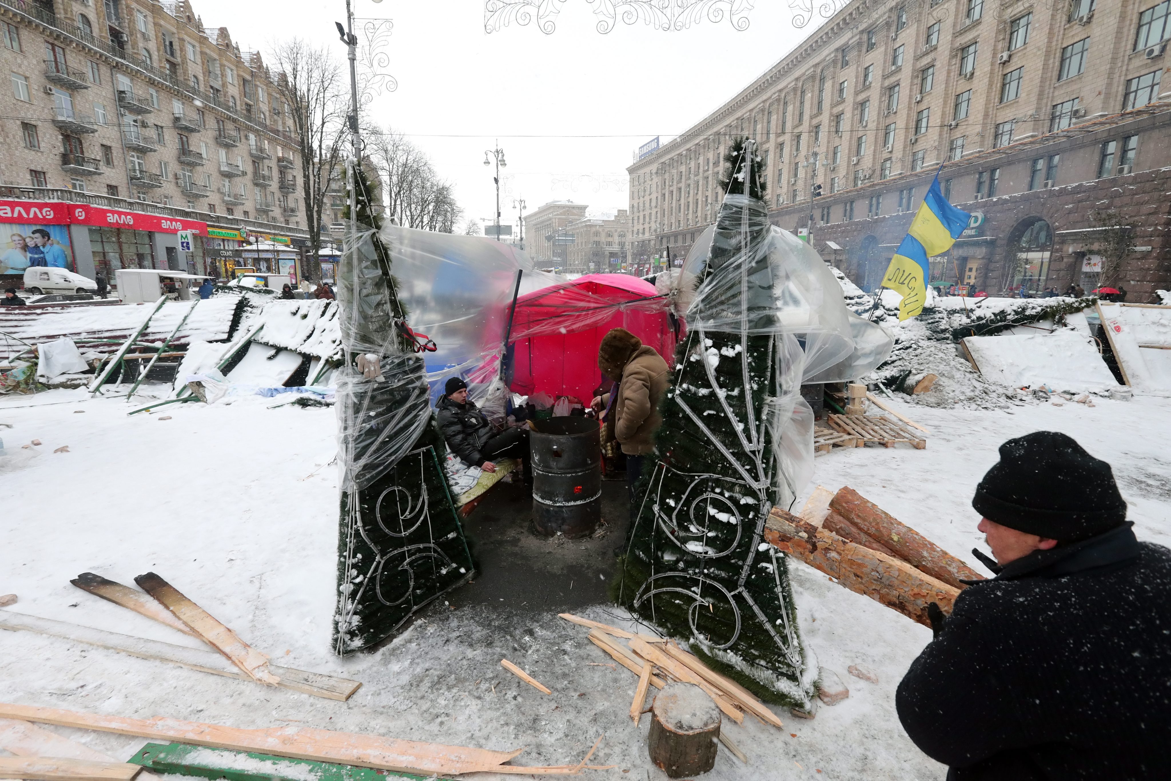 Хора носят дърва за огрев на площада