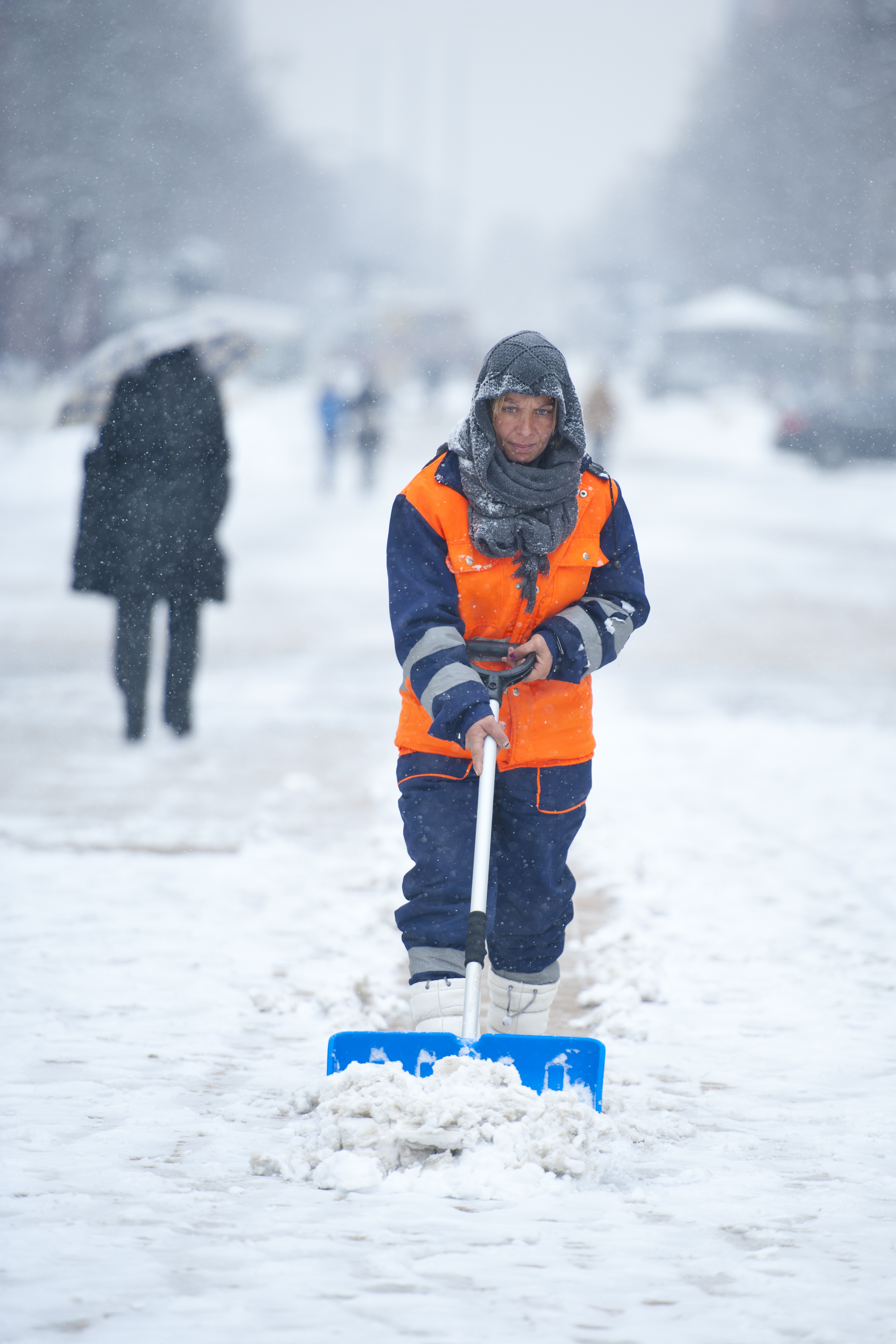 Общински служител почиства снега