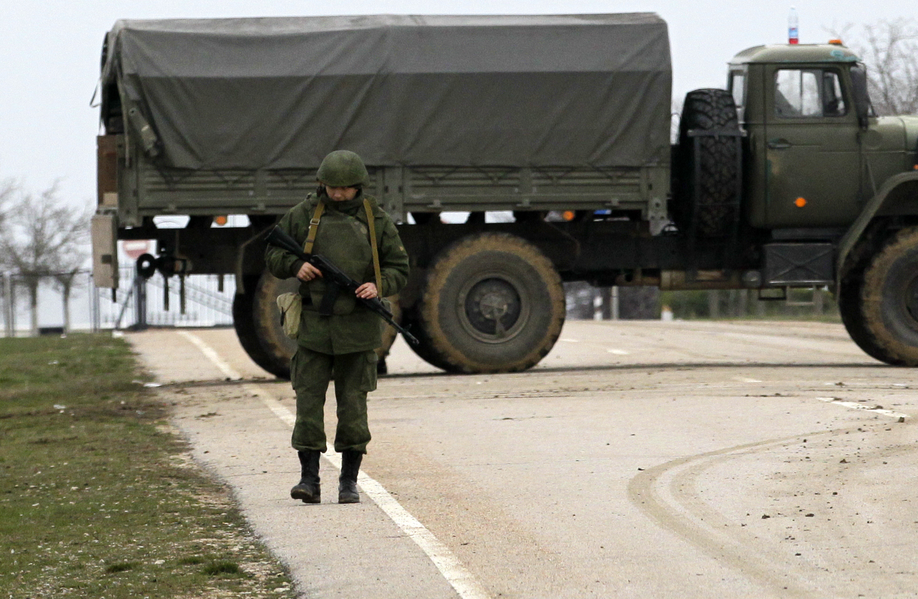 Въоръжен мъж охранява пътя към военното летище на Черно море в Севастопол