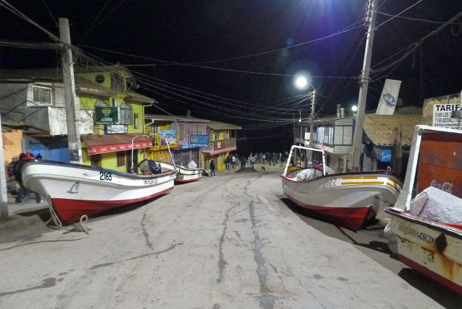 Рибарски лодки са изтласкани на улицата по брега от вълните