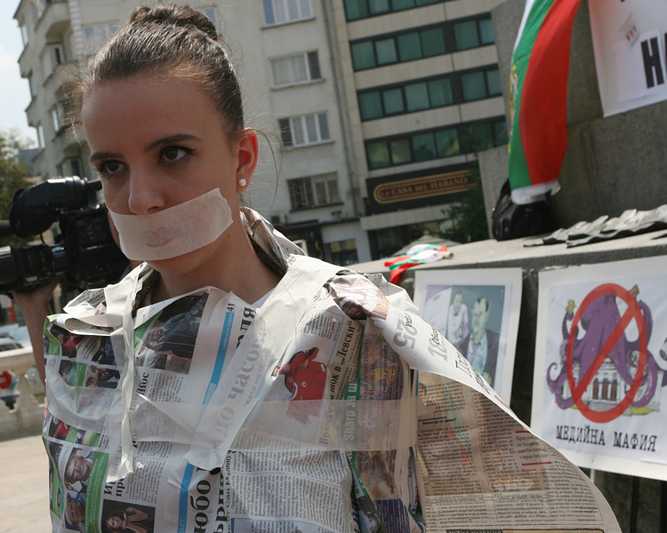 Хората, които подкрепят протеста, бяха увити във вестници като усмирителни ризи