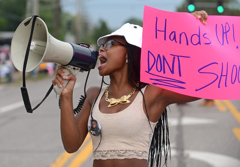 Чернокожа демонстрантка държи плакат на протест във Фергюсън