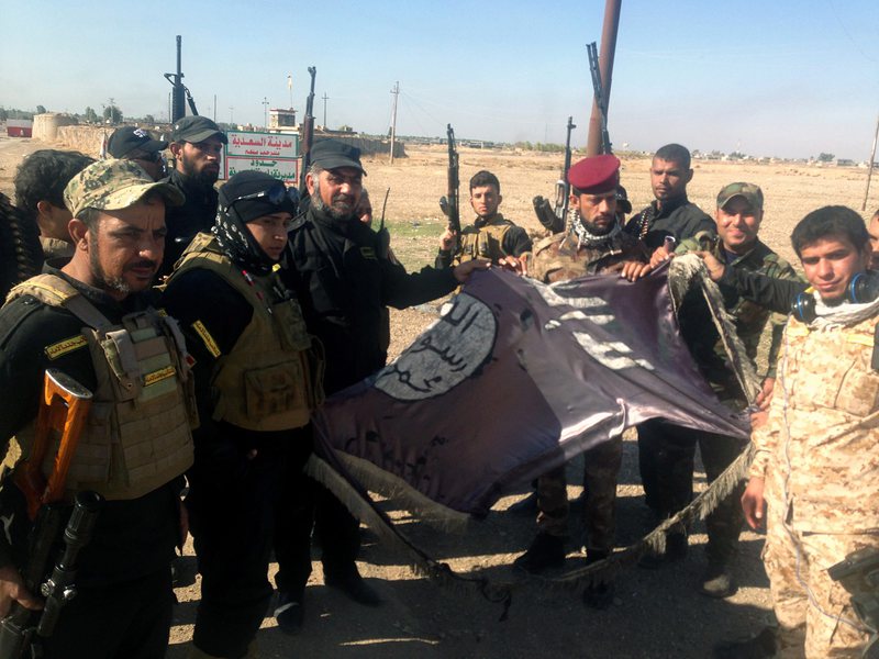 Иракски войници държат свалено знаме на Ислямска държава