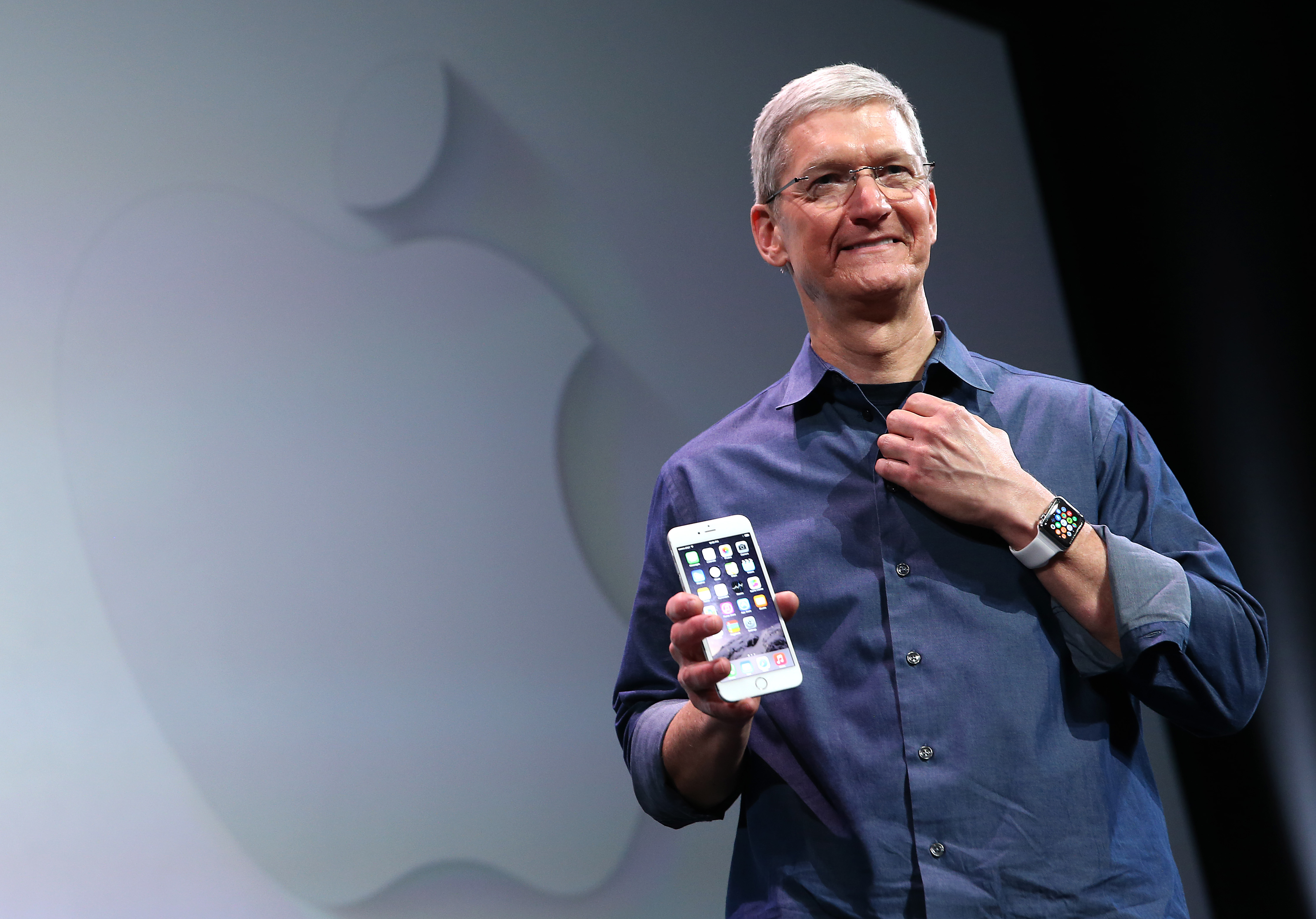 Главният изпълнителен директор на Apple Тим Кук с iPhone 6 и Apple Watch