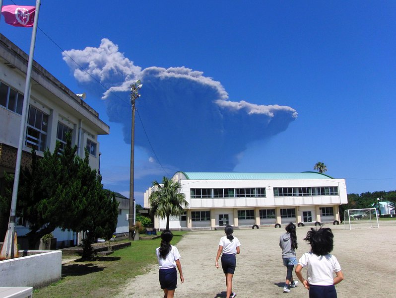 Деца от основното училище Нагата на остров Якушима наблюдават стълба вулканична пепел от малкия остров Кутиноерабу