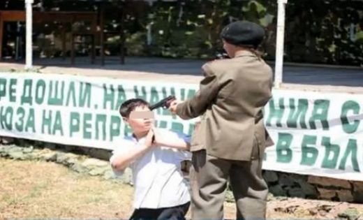 Сцена от спорния спектакъл, в която дете насочва пистолет в главата на друго