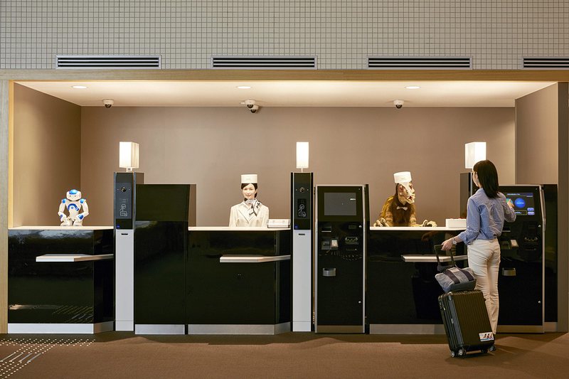 Роботи на рецепцията обслужват клиенти в японски хотел