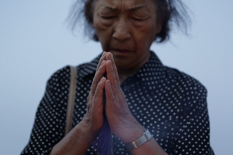 Жена се моли за жертвите на бомбардировката на Хирошима