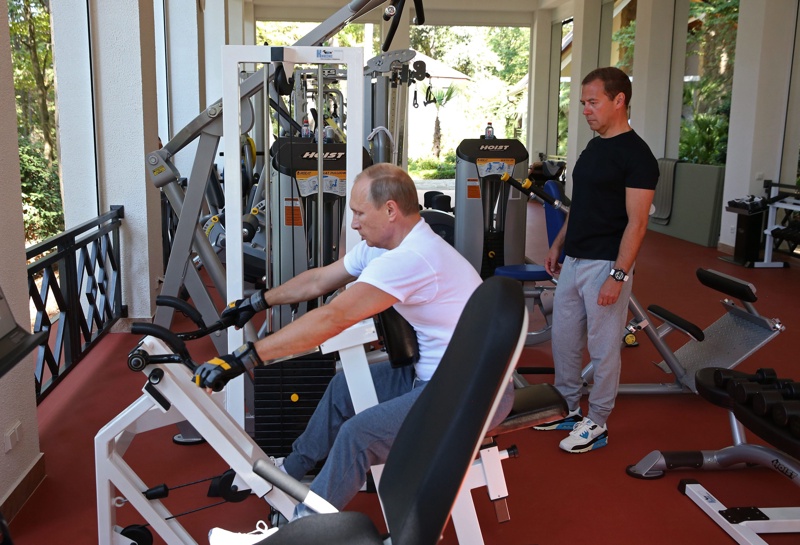 Снимките показват как руският президент - с бяла тениска, анцуг и маратонки - тренира на фитнес уред