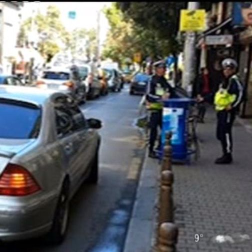 Пътни полицаи пият кафе до неправилно паркирал автомобил