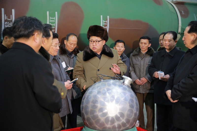 Севернокорейският лидер Ким Чен Ун разглежда ”миниатюризираната” ядрена бойна глава според тази снимка, разпространена от държав