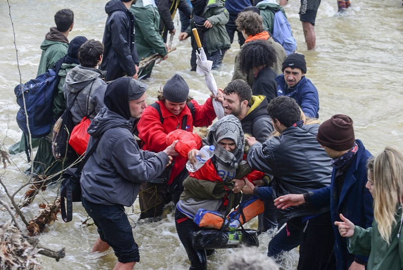 Мигранти от лагера край село Идомени пресичат реката в опит да намерят алтернативен маршрут към Македония