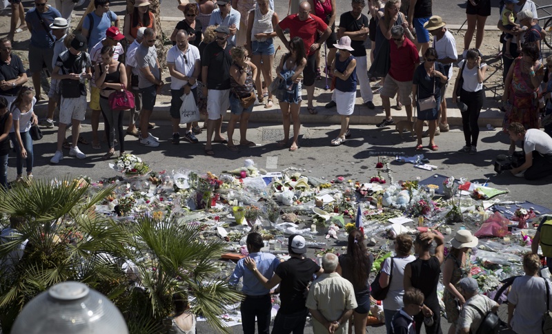 Хора полагат цветя и палят свещи на мястото на трагедията в Ница
