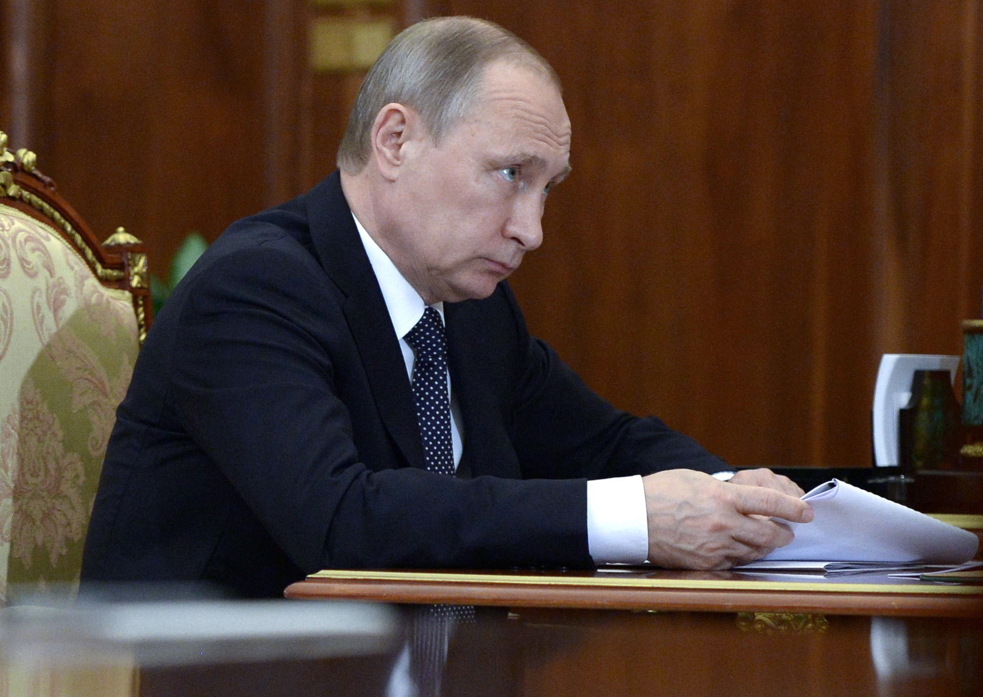 Владимир Путин държи документи по време на днешна среща в Кремъл