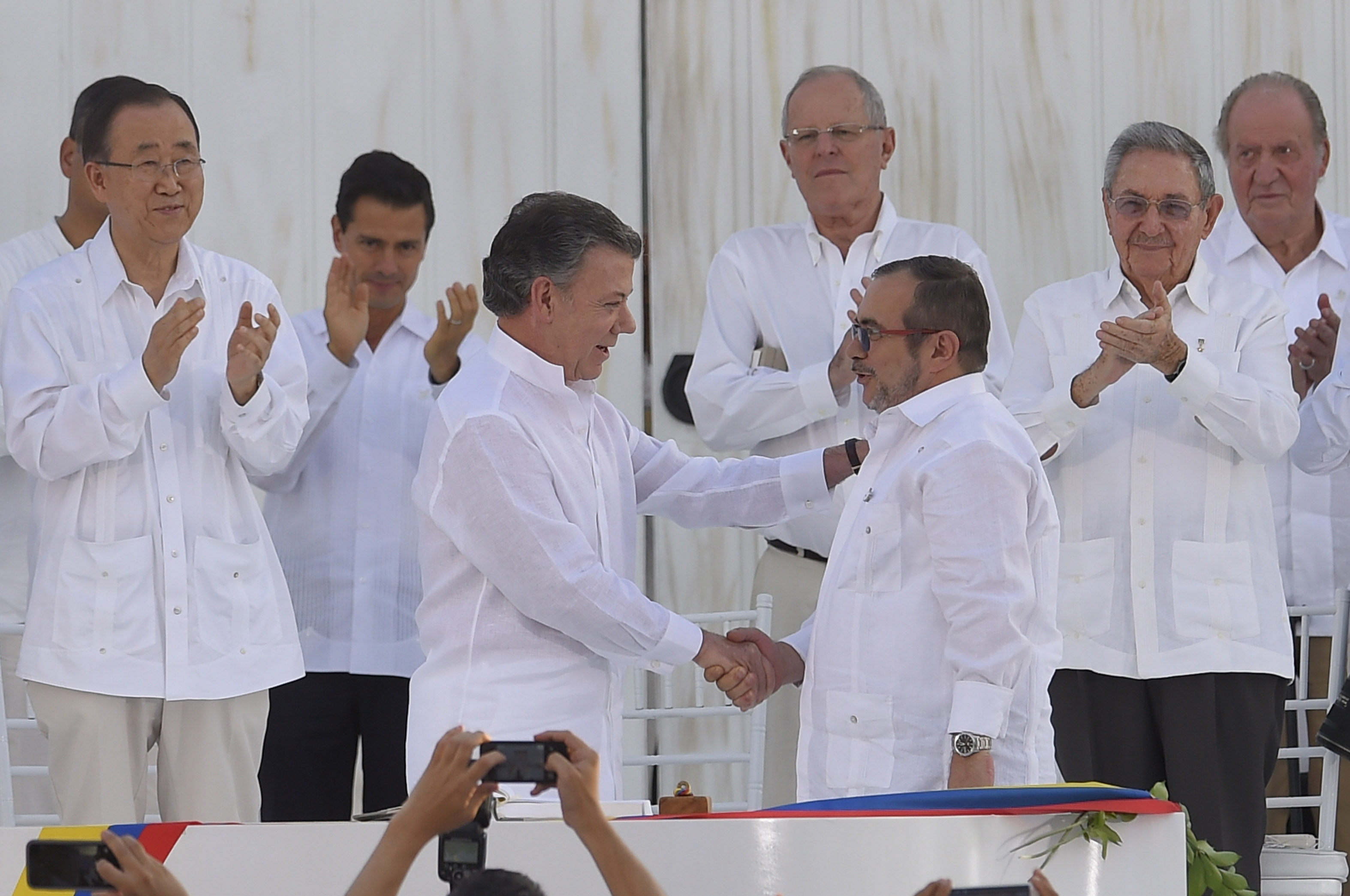 Колумбийският президент Сантос (вляво) и командир на ФАРК се поздравяват след подписване на историческото споразумение