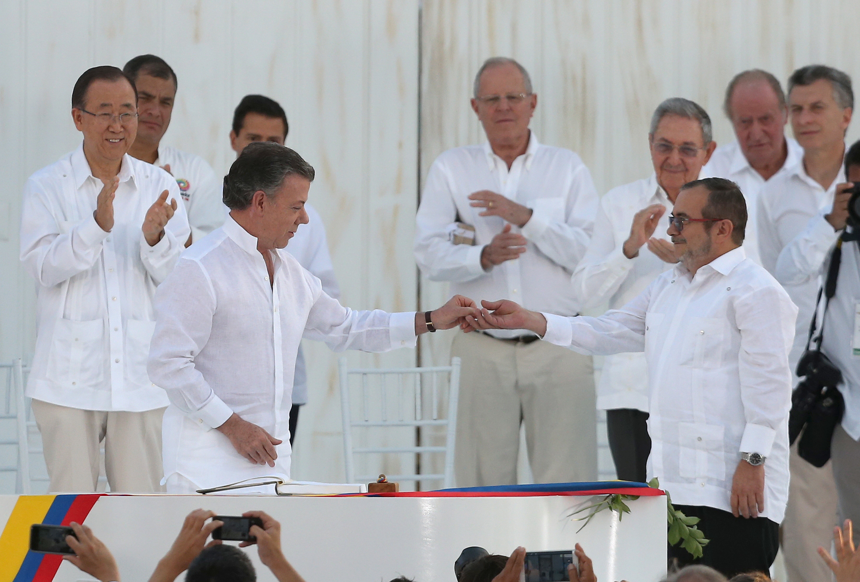 Президентът Хуан Мануел Сантос подава химикалката за мир на командира на лявата бунтовническа организация Родриго Лондоньо