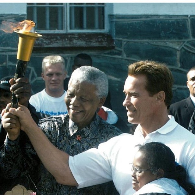 2012 г. Нелсън Мандела и Арнолд Шварценегер палят факел на остров Робен, където той е лежал в каторга, за да популяризират Special Olympics 