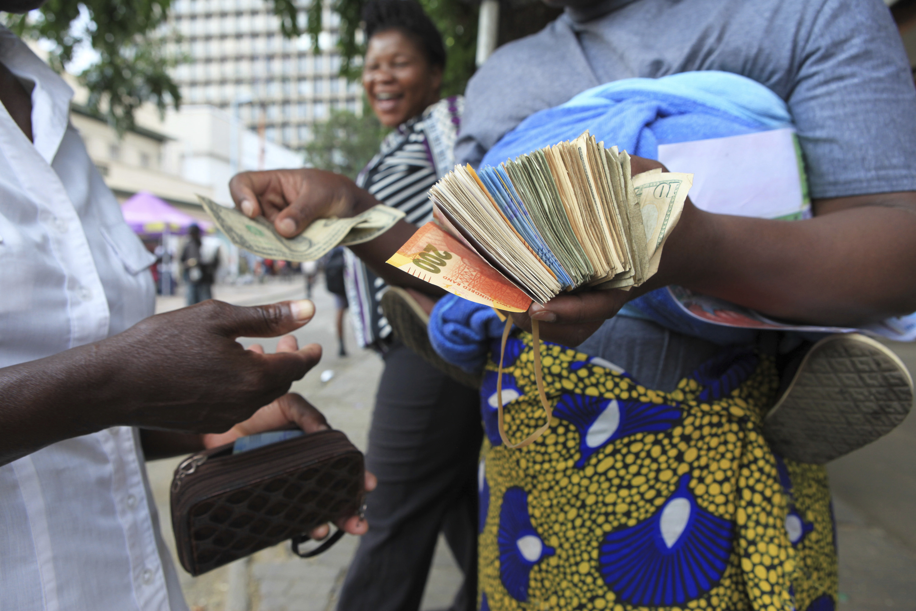 Улична обмяна на пари в Хараре. Около 5 щ.д. струва една банкнота от 100 трилиона долара на Зимбабве