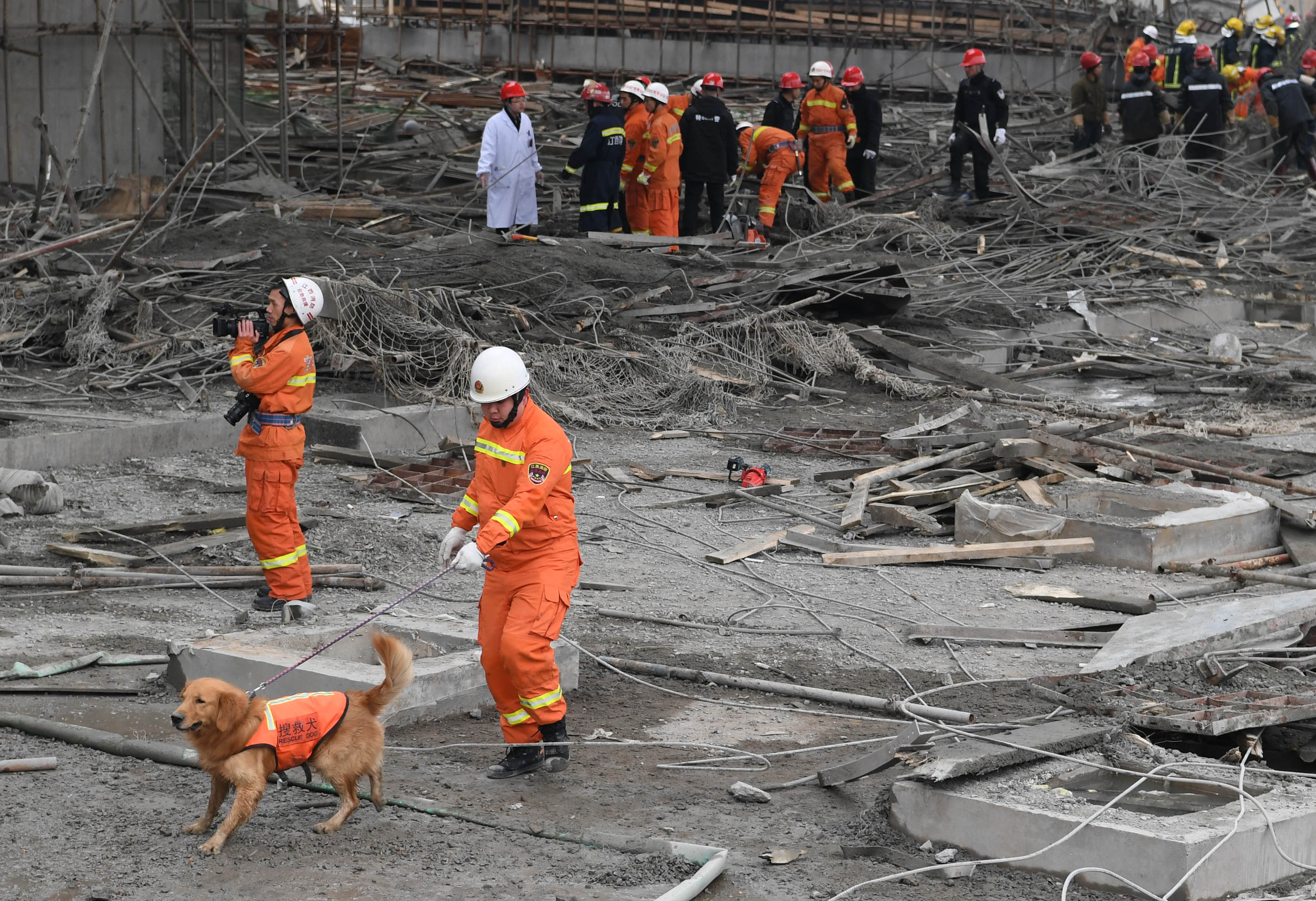 Спасители с обучени кучета работят на мястото на сриналата се тежка конструкция в Китай