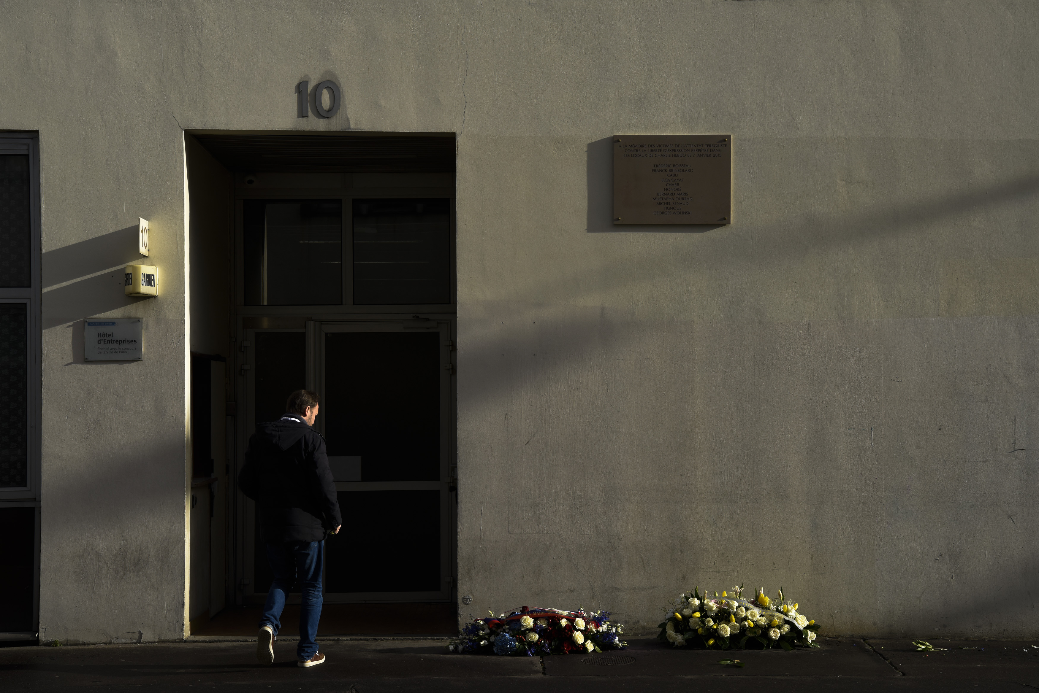 Възпоменателна табела и венци пред офиса на ”Шарли ебдо”, превърнал се в място на кървава трагедия