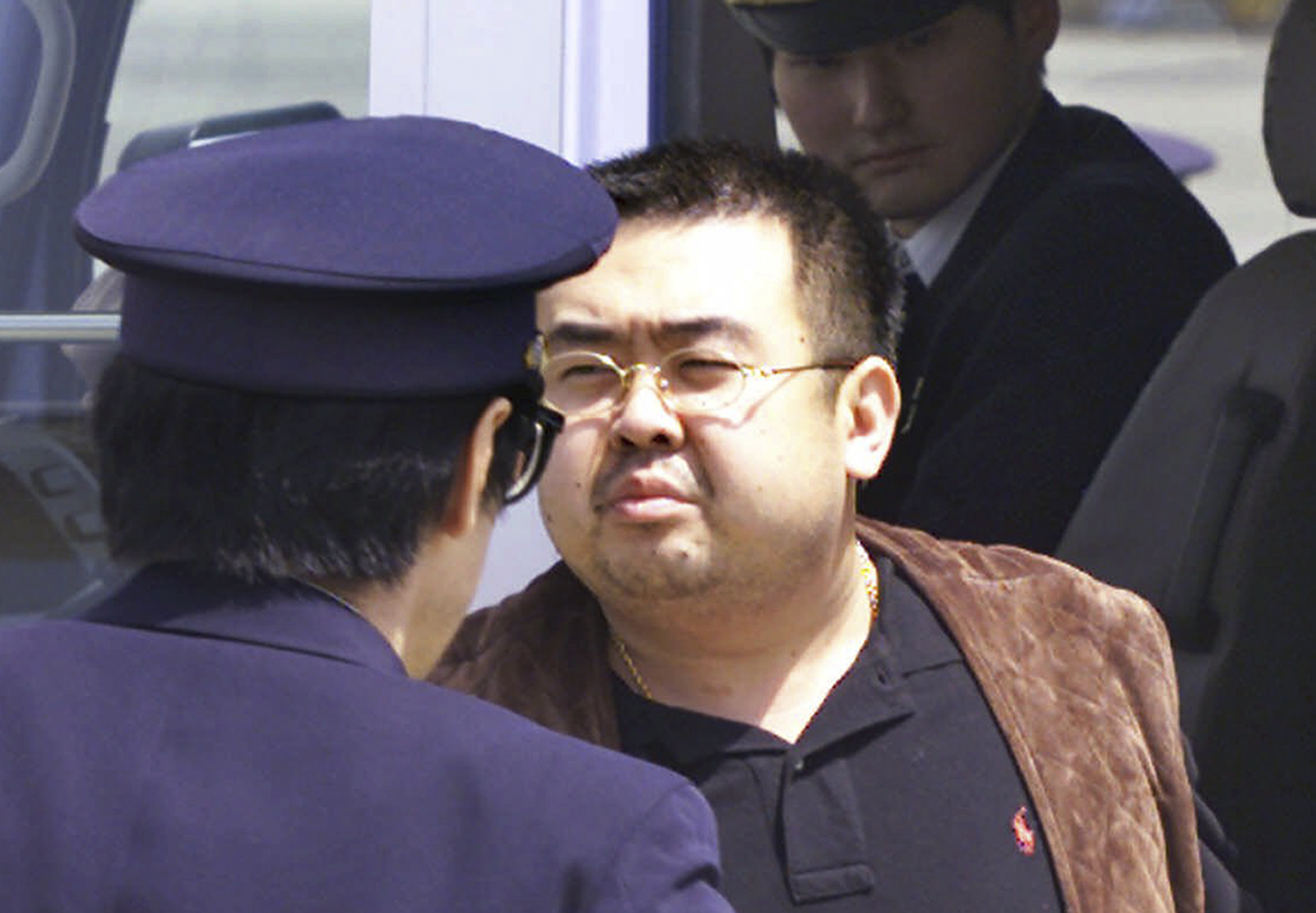 Ким Чен-нам, сниман през 2001 г. на летище Нарита в Япония, заедно с местни полицаи