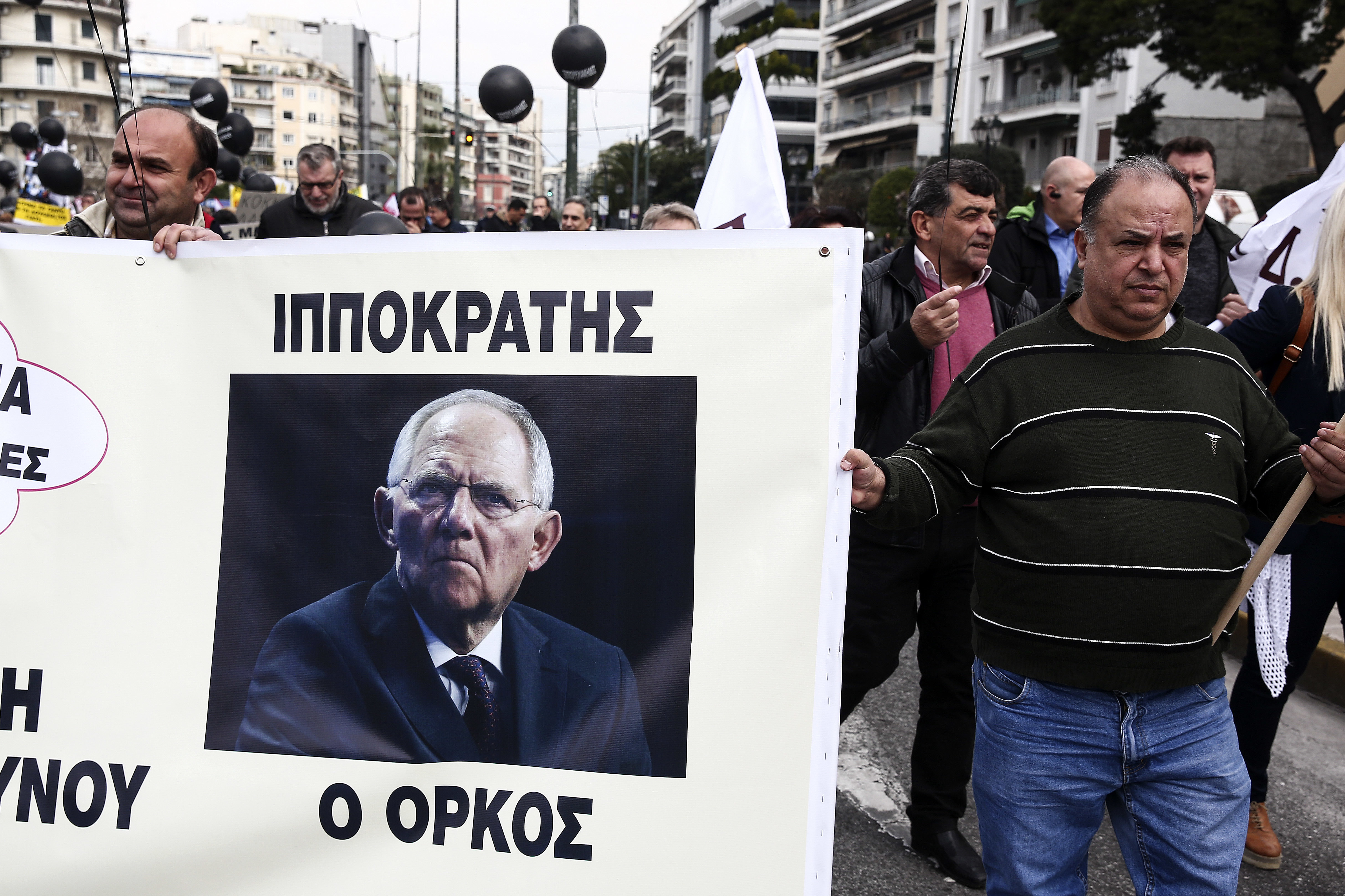 Служители на държавни болници протестират против икономиите с плакат с лика на Шойбле и надпис ”Хипократoвата клетва”