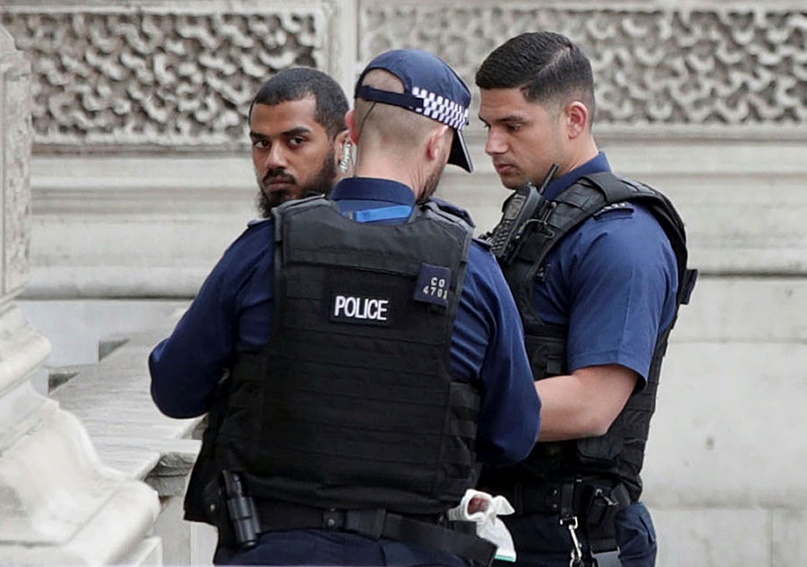 Лондонски полицаи разговарят с минувач след извърнения арест