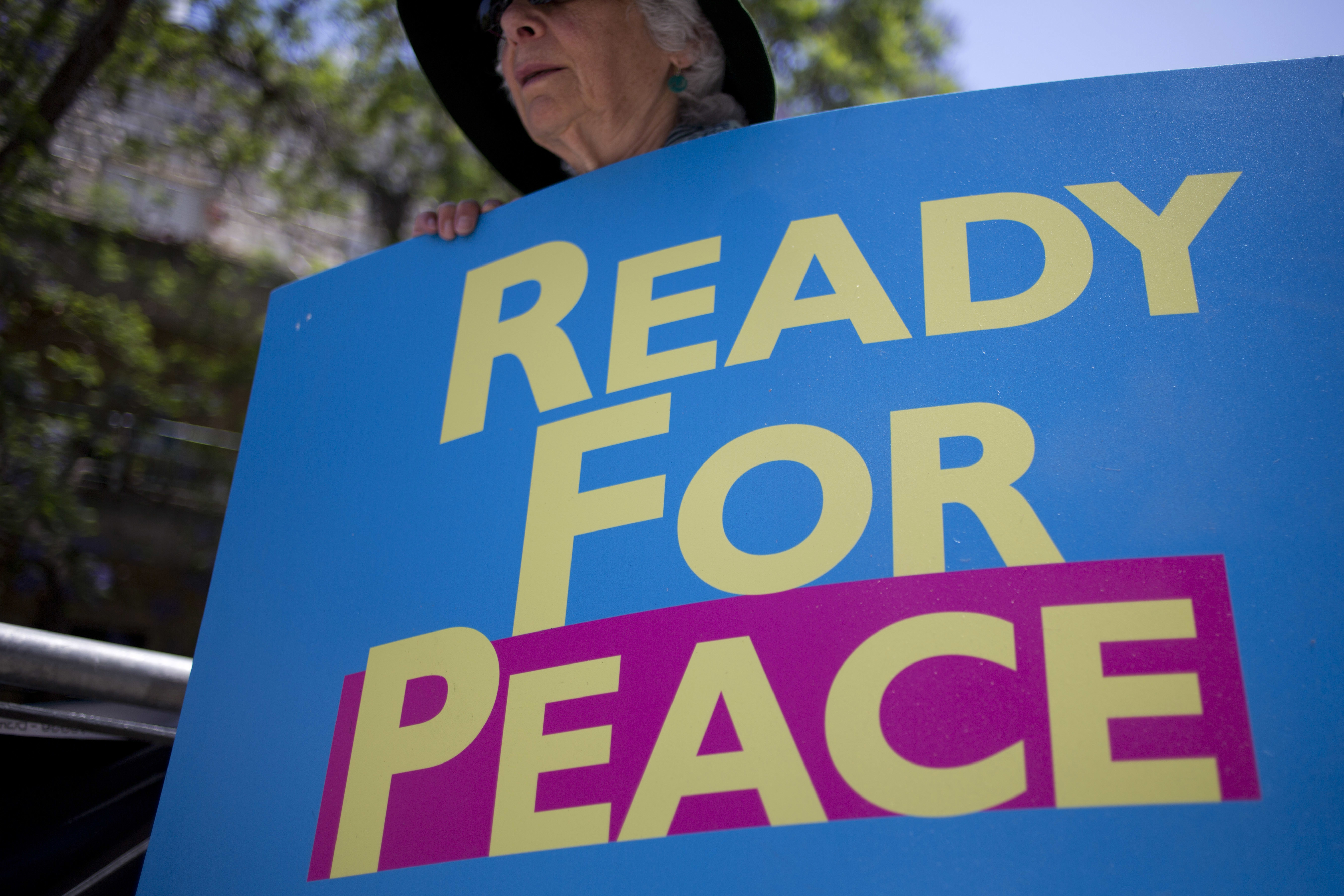 Демонстрант държи плакат "Готови за мир" при пристигането на Тръмп в Израел