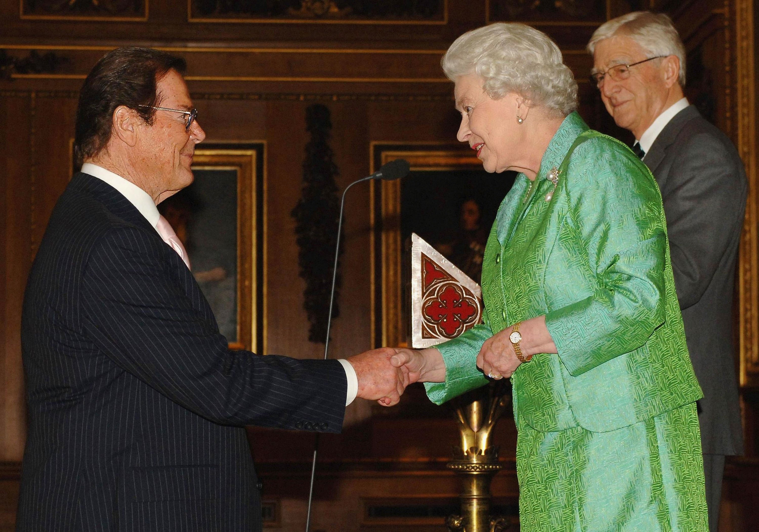 Роджър Мур и кралица Елизабет II се поздравяват като равни