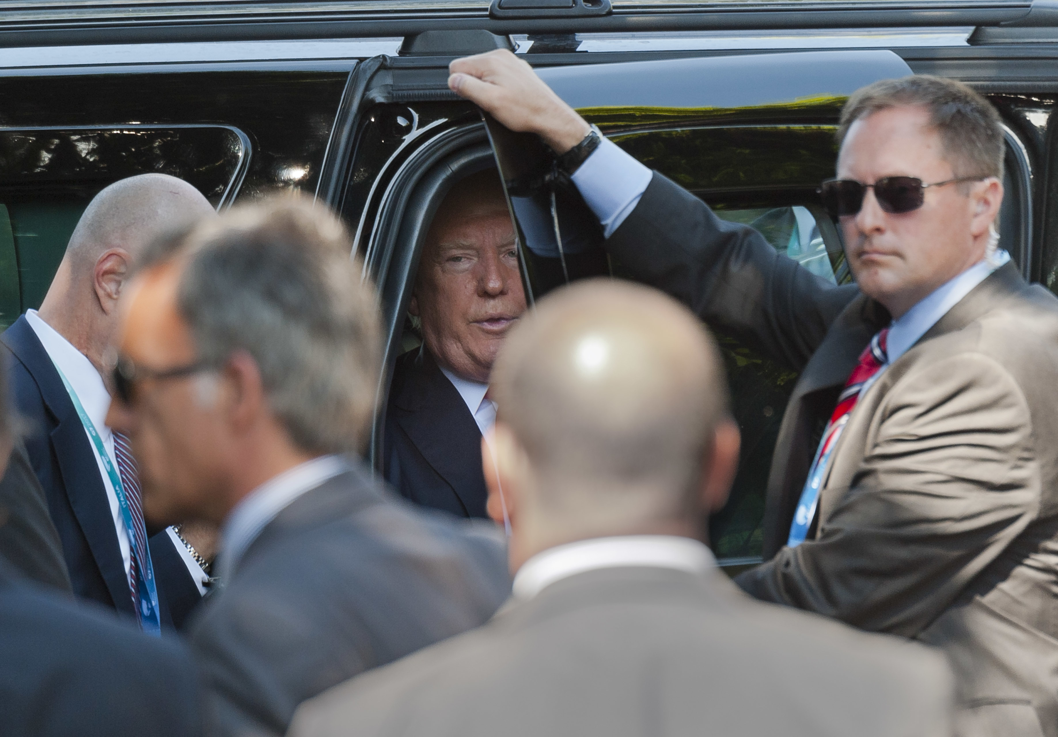 Доналд Тръмп слиза от колата си на срещата на Г-7 в Италия, обграден от охранители