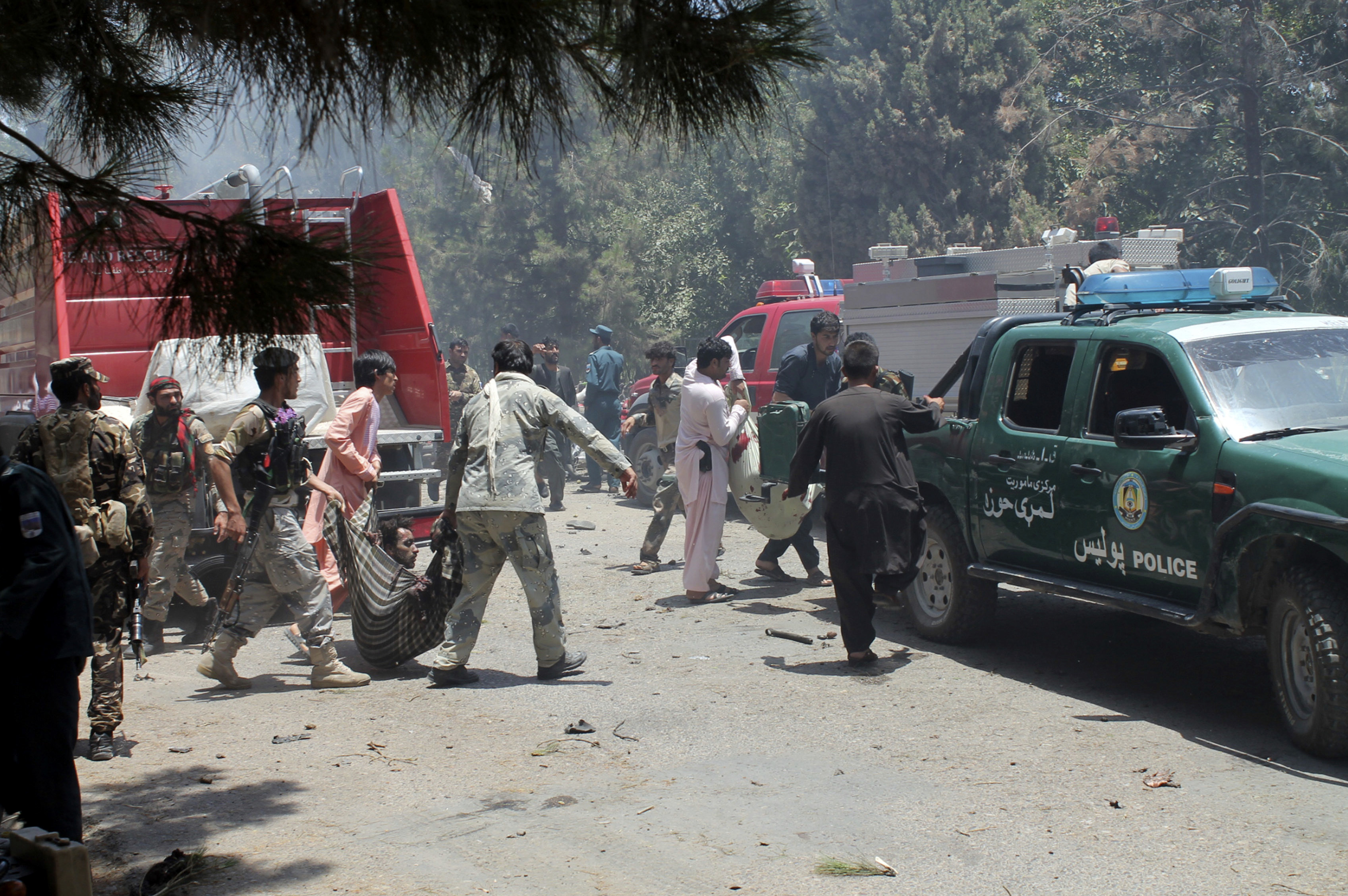 Афганистански военни помагат при изнасяне на ранени след атентата в Хелманд