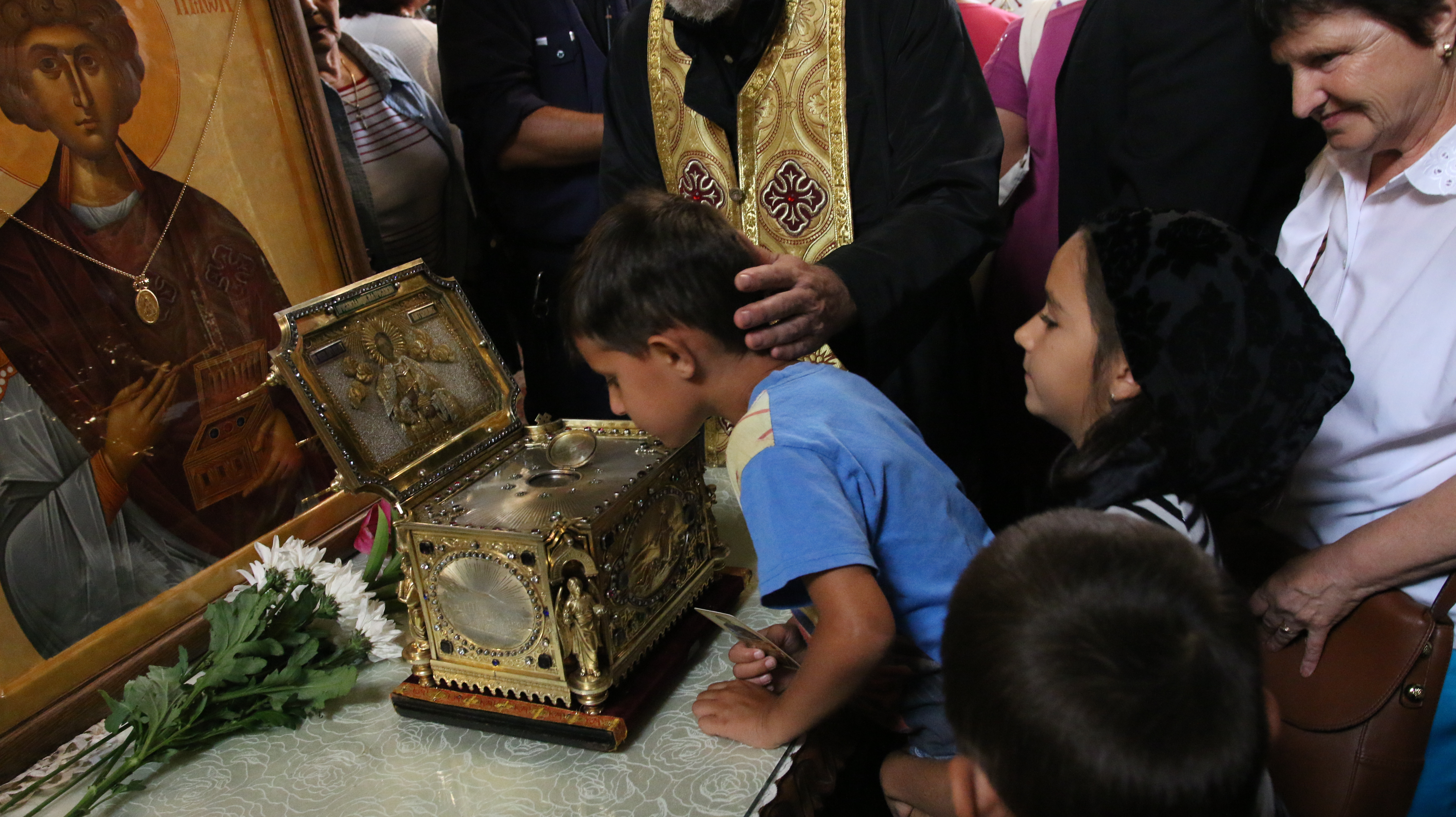 Дете се покланя пред мощите и иконата на Свети Панталеймон